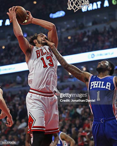 Joakim Noah of the Chicago Bulls rebounds as Tony Wroten of the Philadelphia 76ers gets his hand in his face at the United Center on December 14,...