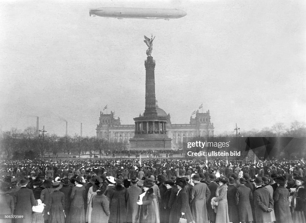 Berlin, zeppelin 'Hansa' over the Berlin Victory Column (Siegessaeule). Crowd waiting for the Danish royal couple. - 24.02.1913
