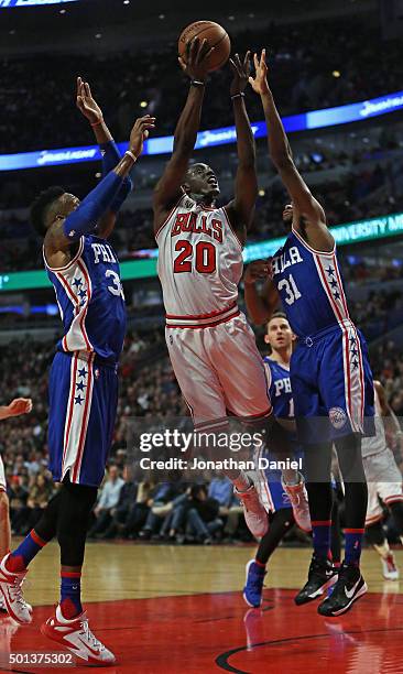 Tony Snell of the Chicago Bulls gets off a shot between Robert Covington and Hollis Thompson of the Philadelphia 76ers at the United Center on...