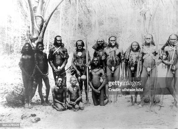 West Papua, male natives with nose jewellery and koteka . - probably in the 1910s
