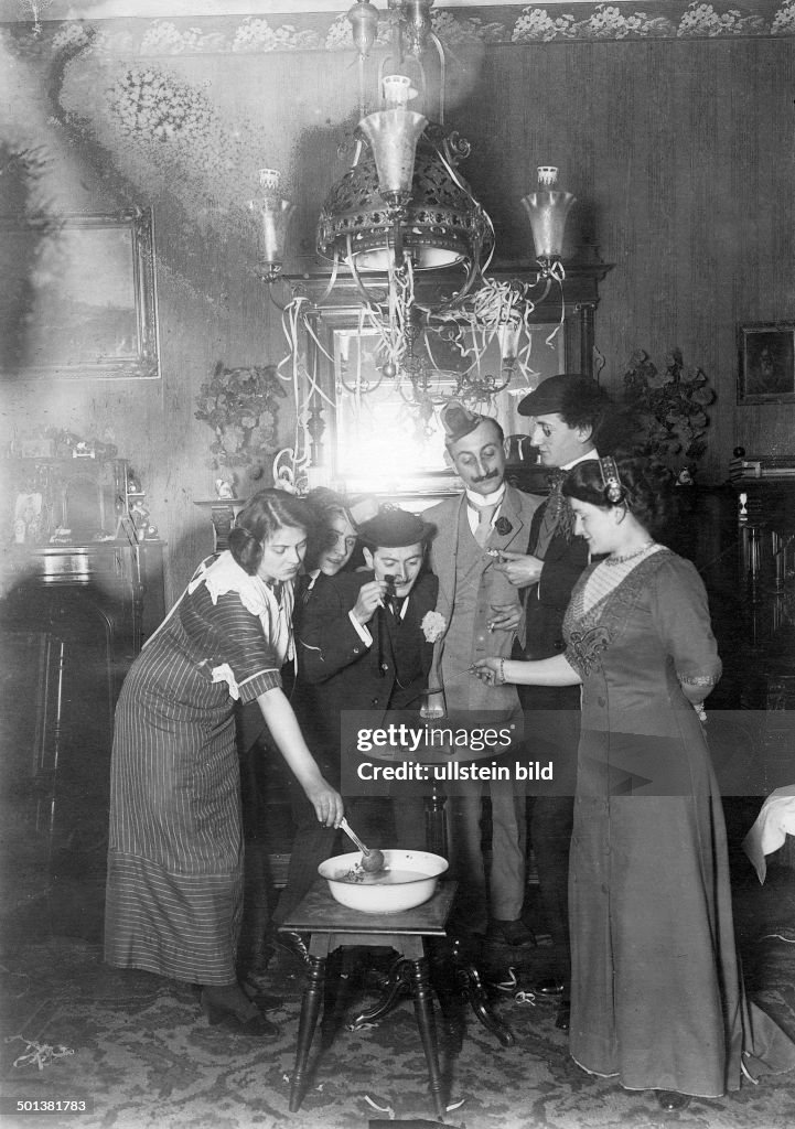 New Year's Eve Party in Germany: party guest are casting lead, a German tradition on this day to predict the future - around 1918