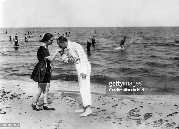 Baltic Sea, Usedom Island: a gentleman kisses a lady on her hand, on the beach of Heringsdorf - in the 1910s