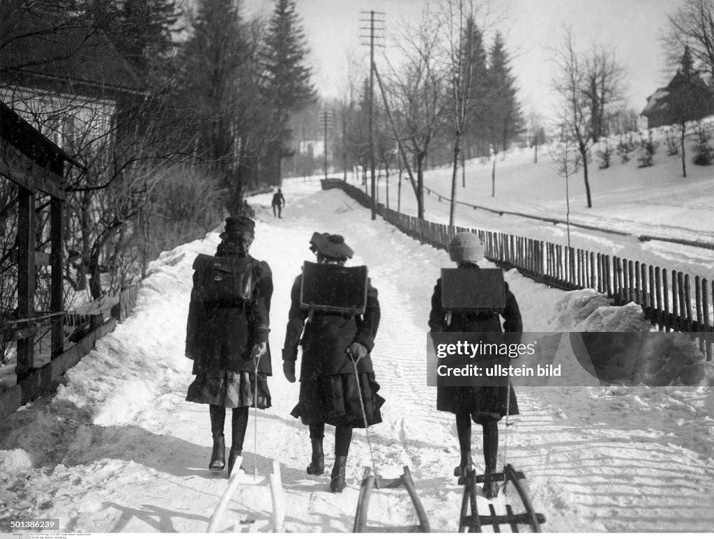 Germany, Province of Silesia, Riesengebirge mountain range, Schreiberhau village: schoolsgirls on their way to school pull sledges - in the 1910s