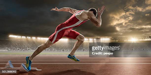 männliche sprinter sprint ab blocks in sportstadion - leichtathletik stock-fotos und bilder