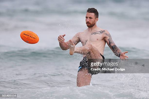 Zach Tuohy of the Blues kicks the ball while participating in a recovery session a the beach during the Carlton Blues AFL pre-season training camp on...