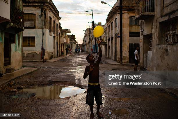 Andris Trujillo tosses a yellow balloon into the air on the evening of August 15, 2015 in the Cerro neighborhood of Havana, Cuba.