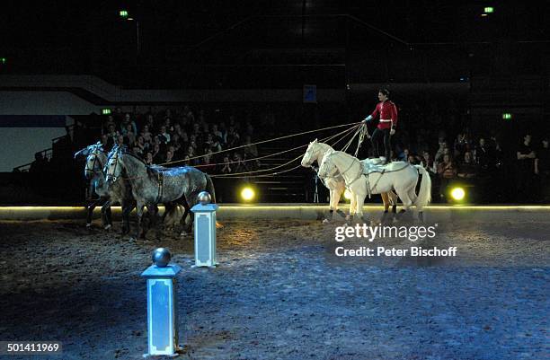 Laury Tisseur steht auf Rücken von 2 Cremello-Hengsten, davor 4 weitere Pferde, Publikum, Pferde-Nummer "Ungarische Post", Pferde-Show "Apassionata"-...