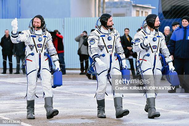 Britain's astronaut Tim Peake, Russian cosmonaut Yuri Malenchenko and US astronaut Tim Kopra walk after their space suits were tested at the...
