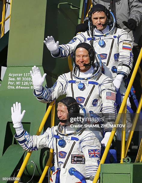 Britain's astronaut Tim Peake , Russian cosmonaut Yuri Malenchenko and US astronaut Tim Kopra wave as they board the Soyuz TMA-19M spacecraft at the...