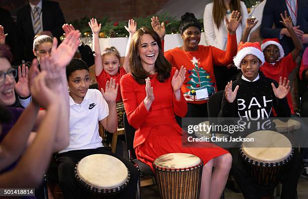 Catherine, Duchess of Cambridge takes part in some drumming 'music therapy' as she attends the Anna Freud Centre Family School Christmas Party at...