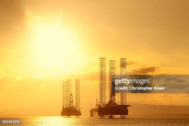 north sea oil platforms at sunset, cromarty firth, scotland - oil industry stock pictures, royalty-free photos & images