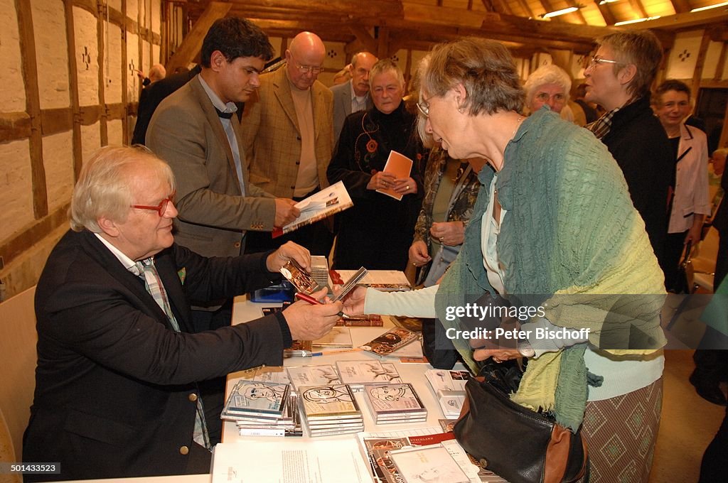 Justus Frantz (li., sitzend, beim Autogramme schreiben), dahinter stehend Mitarbeite