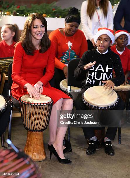 Catherine, Duchess of Cambridge takes part in some drumming 'music therapy' as she attends the Anna Freud Centre Family School Christmas Party at...