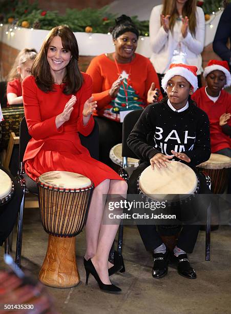 Catherine, Duchess of Cambridge takes part in some drumming 'music therapy' as she attends the Anna Freud Centre Family School Christmas Party at...