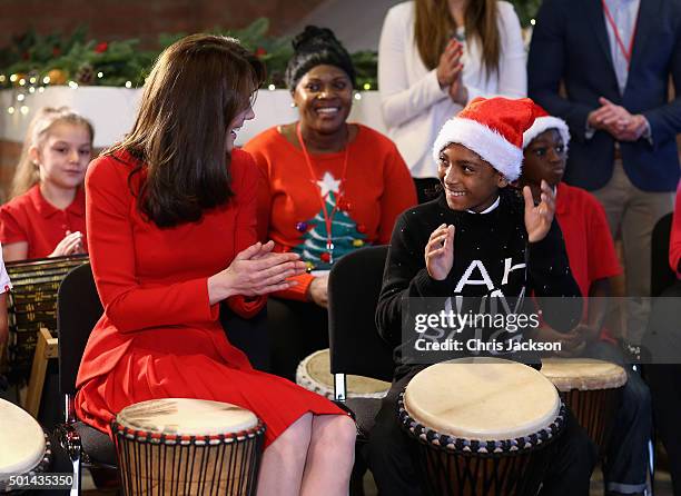 Catherine, Duchess of Cambridge takes part in some drumming 'music therapy' as she attends the Anna Freud Centre Family School Christmas Party at...