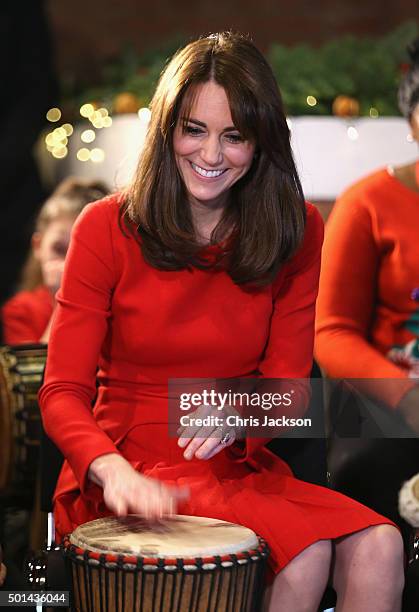 Catherine, Duchess of Cambridge takes part in some drumming 'music therapy' as she attends the Anna Freud Centre Family School Christmas Party at...