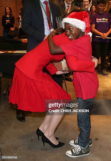 Catherine, Duchess of Cambridge hugs a young boy after receiving as she attends the Anna Freud Centre Family School Christmas Party at the Anna Freud...