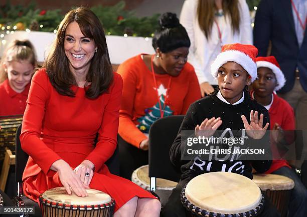 Catherine, Duchess of Cambridge takes part in some drumming 'music therapy' as she attends the Anna Freud Centre Family School Christmas Party at the...