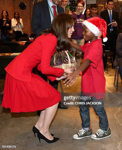 Catherine, Duchess of Cambridge hugs a young boy after receiving as she attends the Anna Freud Centre Family School Christmas Party at the Anna Freud...