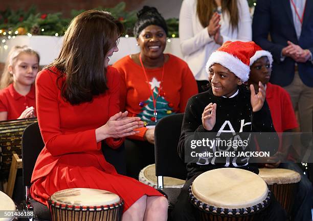 Catherine, Duchess of Cambridge takes part in some drumming 'music therapy' as she attends the Anna Freud Centre Family School Christmas Party at the...