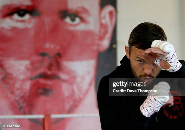 Boxer Andy Lee trains in front of a fight poster of his opponent Billy Joe Saunders, during a media work-out at Arnie's Gym on December 15, 2015 in...