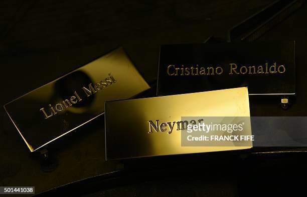 Picture taken on December 15, 2015 shows three plaques reading, "Cristiano Ronaldo", "Lionel Messi" and "Neymar" at the Mellerio jewellers in Paris,...
