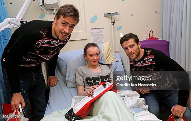 Sebastian Coates and Adam Matthews give a christmas gift to Demi Leigh Hastings at Sunderland Royal Hospital on December 15, 2015 in Sunderland,...