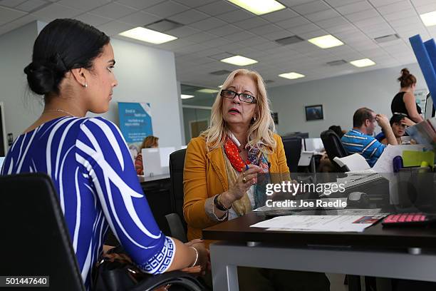 Maria Elena Santa Coloma , an insurance advisor with UniVista Insurance company, helps Shessy Gonzalez sign up for a health plan under the Affordable...