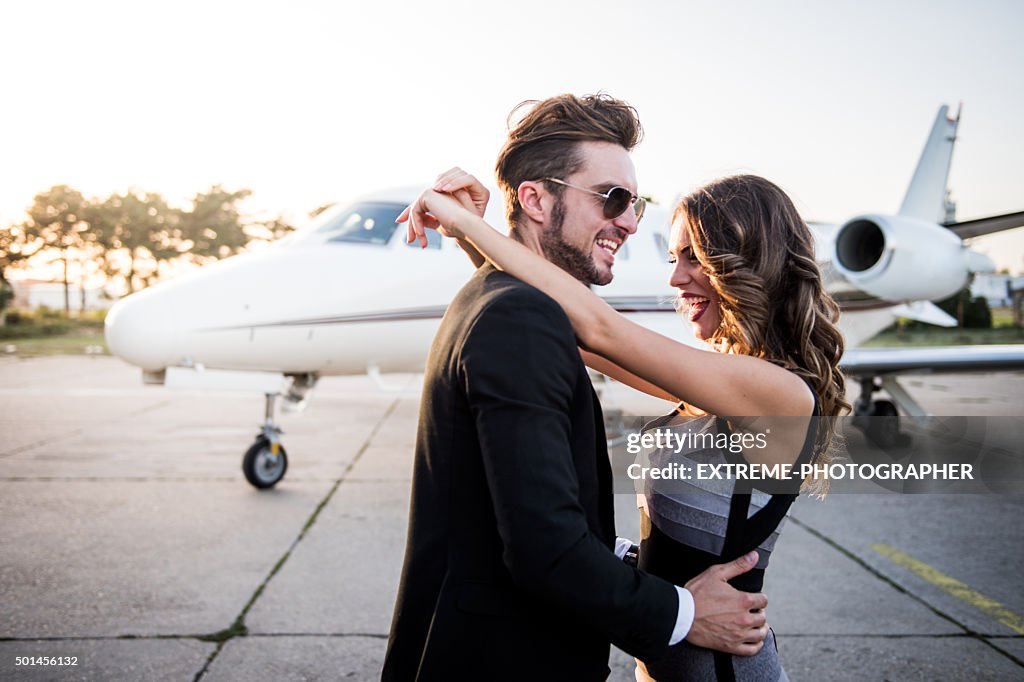 Young famous couple hugging at the airport