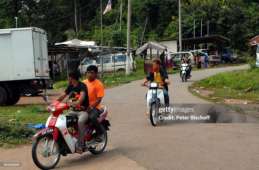 Junge Männer auf Motorrädern, Fischerdorf bei Pantai Cenang, Insel Langkawi, Malaysi