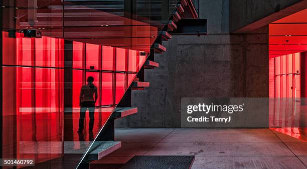 reflection of an individual on staircase at city hall. - red background stock pictures, royalty-free photos & images