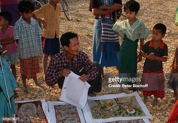 Einheimischer Händler mit Buddha-Stoff-Drucken, Kinder in Festtags-Kleidung, Dorffest, nahe alte Königsstadt Bagan, Myanmar , Asien, Wasser-Schale...