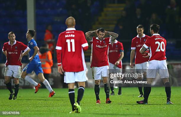 Scott Burton of Salford City and his team-mates look on dejectedly after conceding the first goal in extra time during the Emirates FA Cup second...