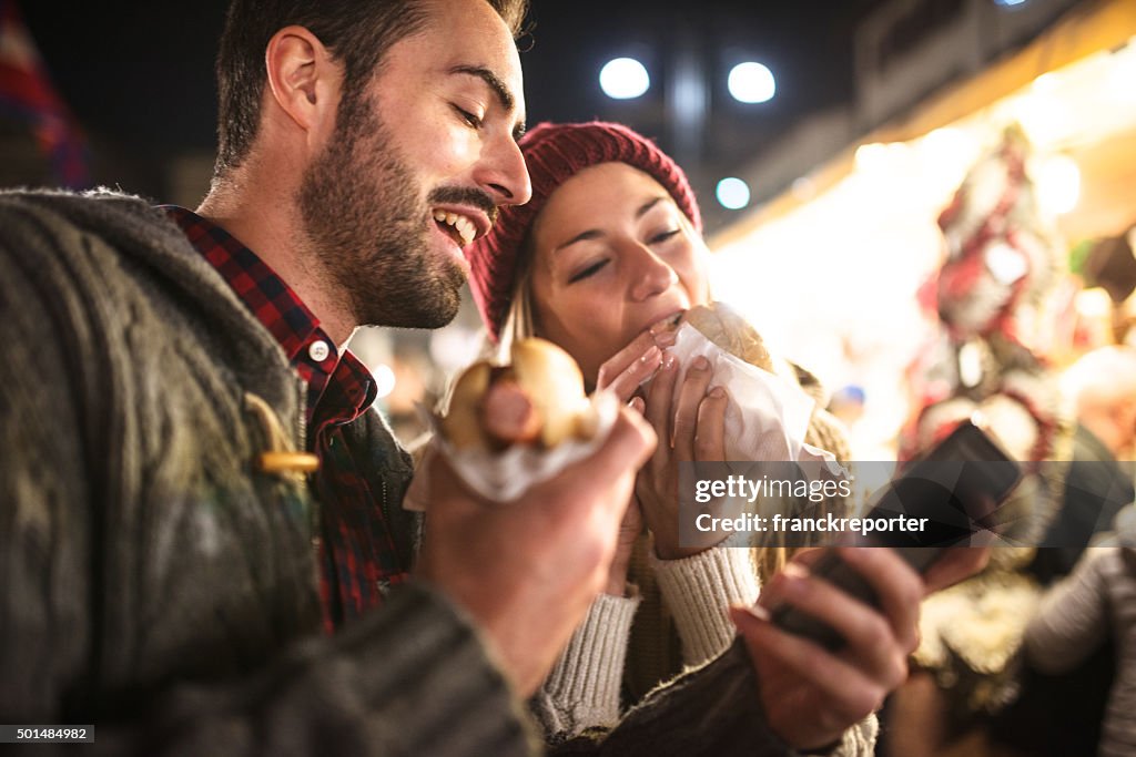 Coppia, mangiare in un mercatino di Natale