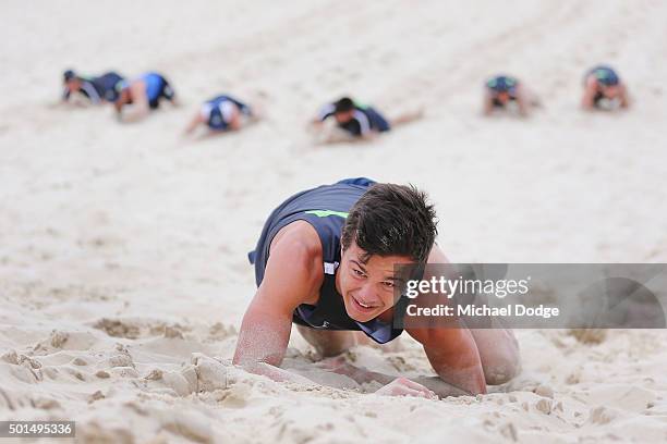 Jack Silvagni commando crawls up a sandune during a circuit training session at Kurrawa Beach during the Carlton Blues AFL pre-season training camp...