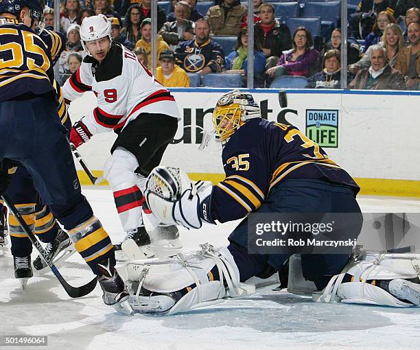 Linus Ullmark of the Buffalo Sabres deflects the puck watched by Jiri Tlusty of the New Jersey Devils during an NHL game on December 15, 2015 at the...