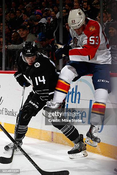 Corban Knight of the Florida Panthers and Thomas Hickey of the New York Islanders battle for the puck during the game at the Barclays Center on...