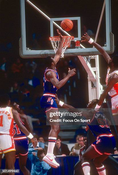 James Bailey of the New Jersey Nets block the shot of Tree Rollins of the Atlanta Hawks during an NBA basketball game circa 1982 at the Omni Coliseum...