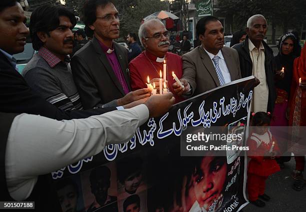 Pakistani workers of christian community, Revival Church International hold candles during a vigil to pay tribute to the victims of the Peshawar...