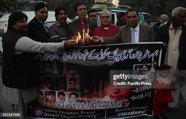 Pakistani workers of christian community, Revival Church International hold candles during a vigil to pay tribute to the victims of the Peshawar...