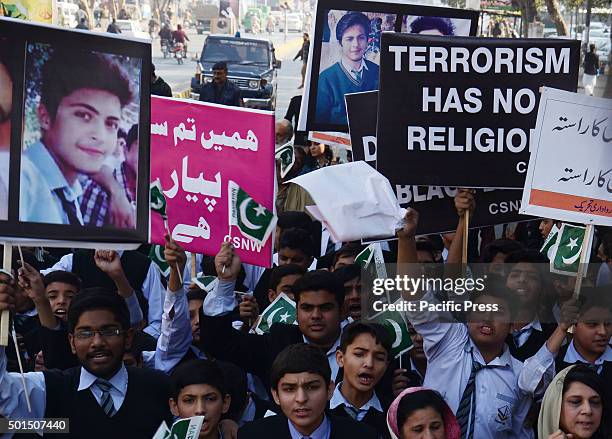 Pakistani students,teachers and civil society activists carry placards as they march during a rally to pay tribute to the victims of the Peshawar...