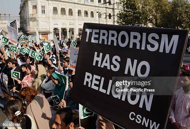 Pakistani students,teachers and civil society activists carry placards as they march during a rally to pay tribute to the victims of the Peshawar...