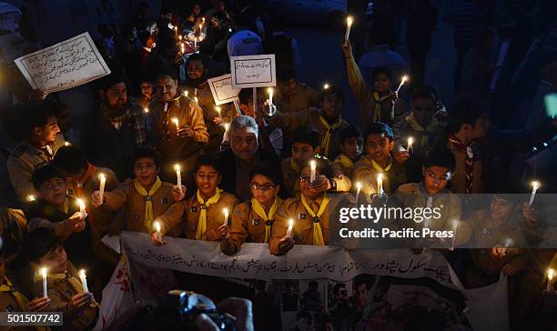Pakistani students,teachers and civil society activists hold lit candles during a vigil to pay tribute to the victims of the Peshawar school massacre...
