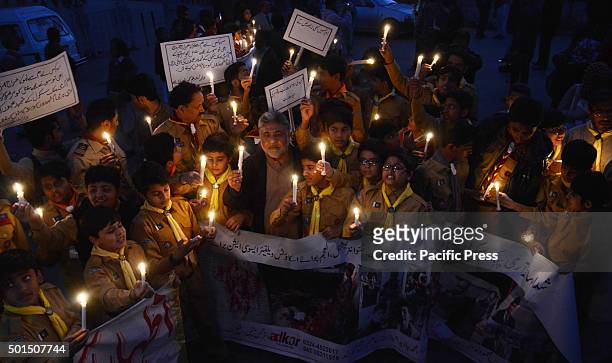 Pakistani students,teachers and civil society activists hold lit candles during a vigil to pay tribute to the victims of the Peshawar school massacre...