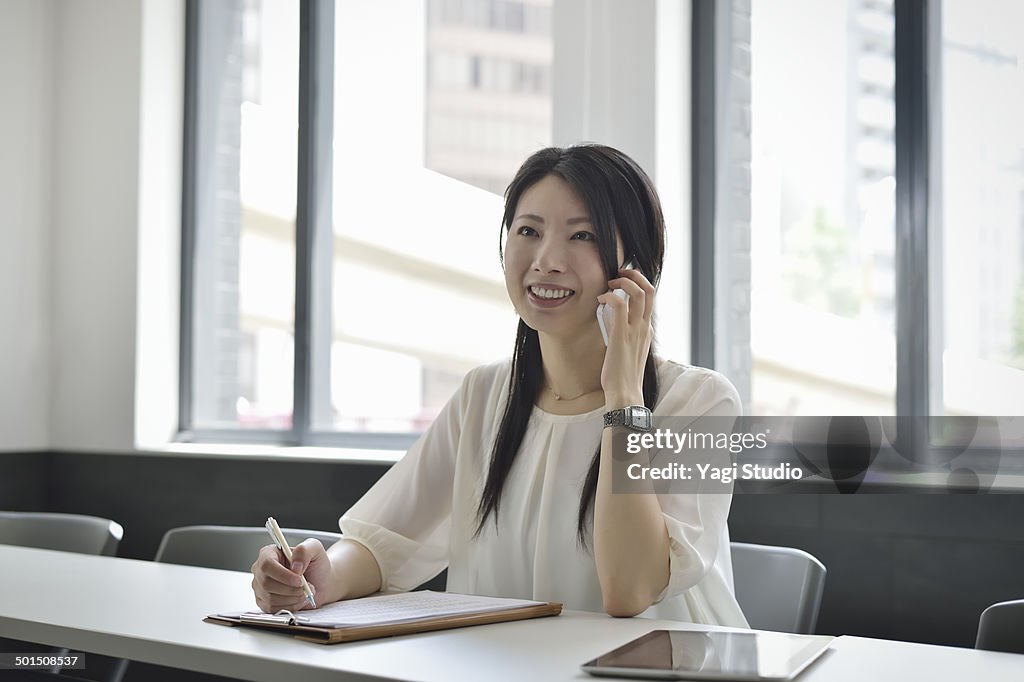 Businesswoman using smartphone in meeting room