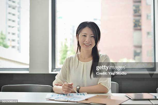 businesswoman working in meeting room - 女性　日本人　笑顔　30代 ストックフォトと画像