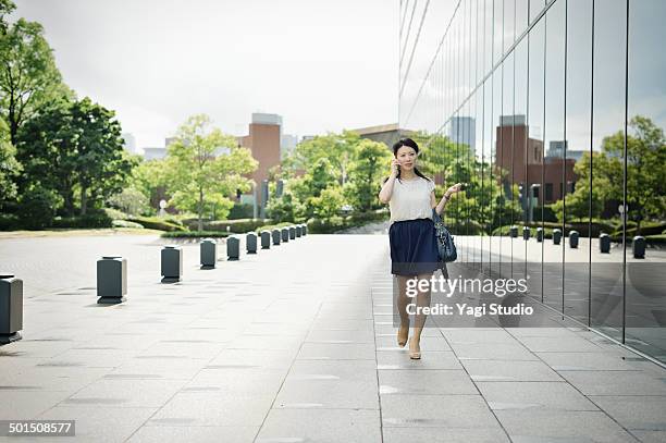 woman walking in front of office building - short skirt stock pictures, royalty-free photos & images