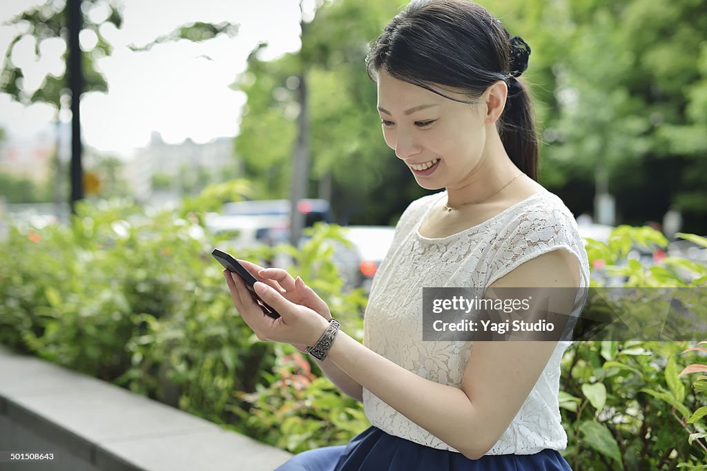 Woman using smartphone in urban park