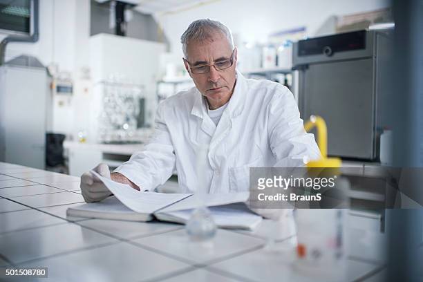senior forensic scientist reading medical data in laboratory. - doctor publication stock pictures, royalty-free photos & images