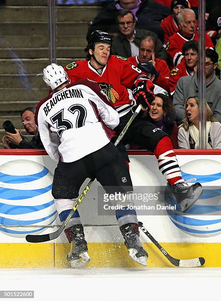 Andrew Shaw of the Chicago Blackhawks collides against the boards with Francois Beauchemin of the Colorado Avalanche at the United Center on December...